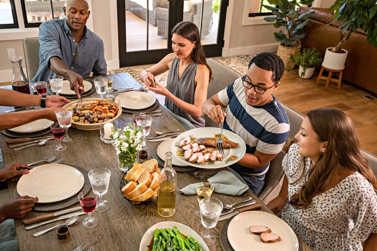 Family and friends gathered around the table enjoying a delicious holiday dinner of pork tenderloin.